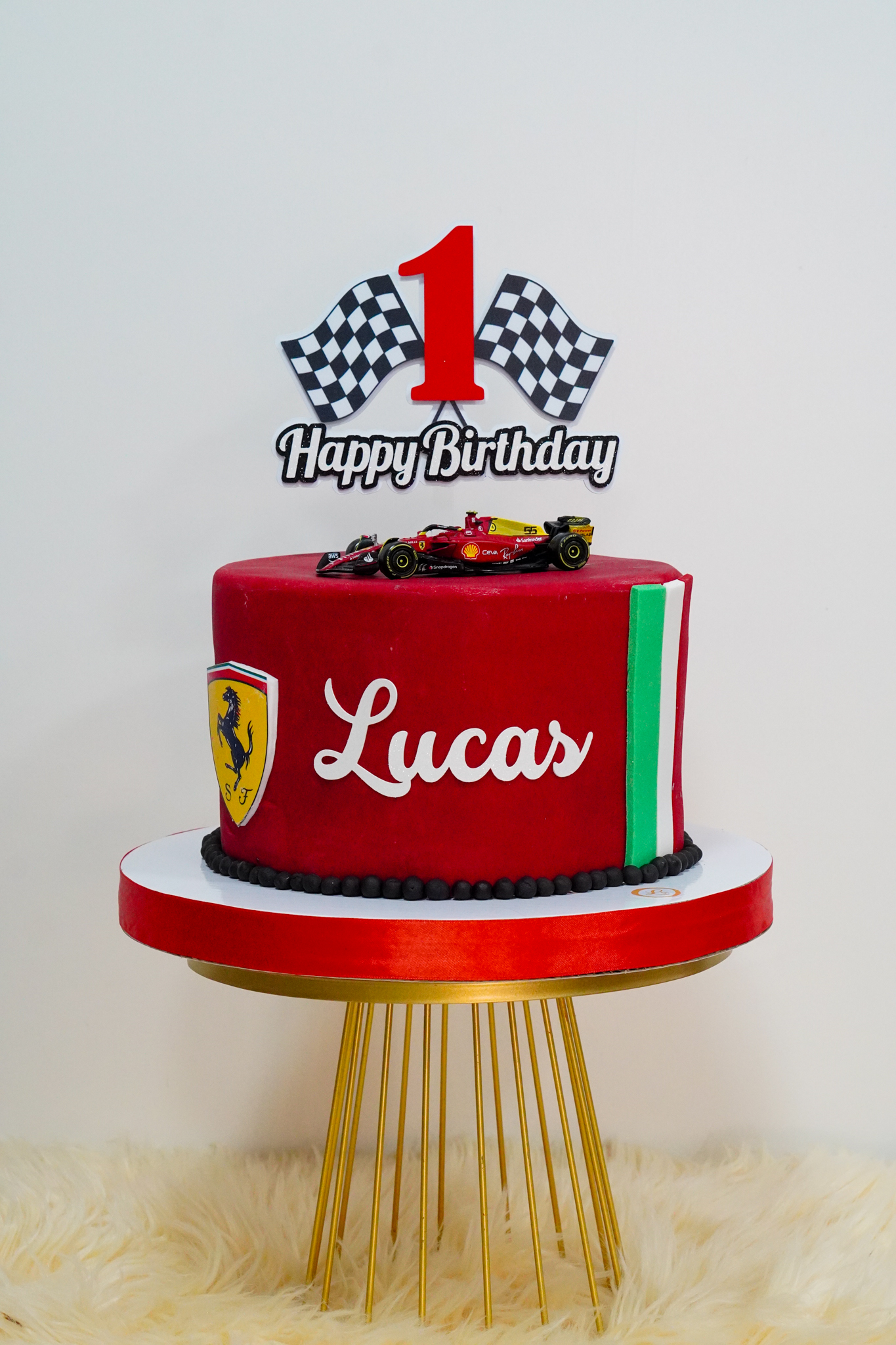 Ferrari Formula 1 themed birthday cake with red fondant, race car topper, and checkered flag decoration