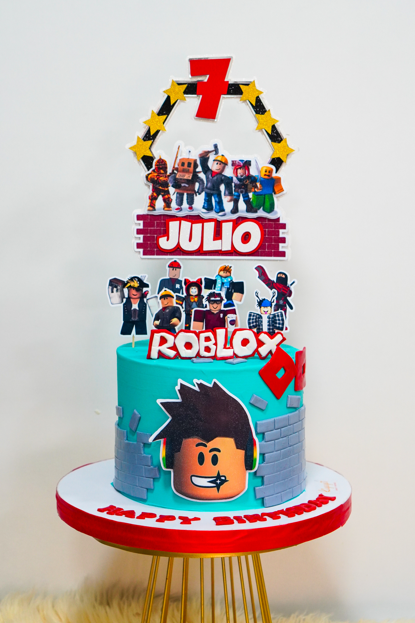 Roblox-themed birthday cake with character toppers, number 7, and brick wall decorations